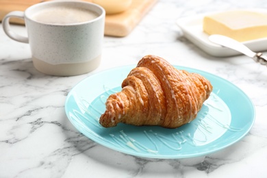 Photo of Plate of fresh croissant with condensed milk on white marble table. French pastry