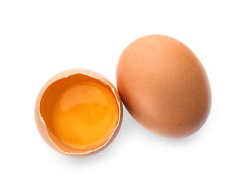 Photo of Cracked and whole chicken eggs on white background, top view