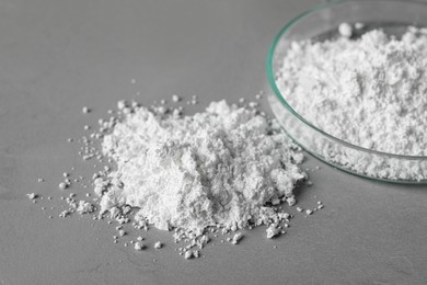 Photo of Petri dish and calcium carbonate powder on grey table