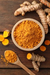 Photo of Aromatic turmeric powder and raw roots on wooden table, flat lay