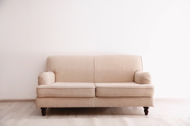 Photo of Simple living room interior with comfortable sofa near white wall