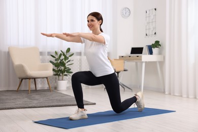 Happy woman doing morning exercise at home