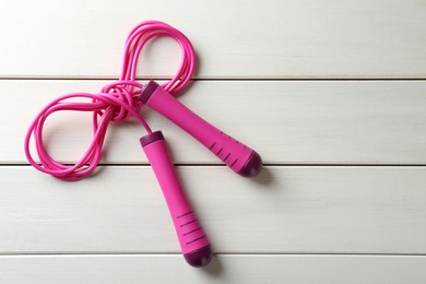 Photo of Skipping rope on white wooden table, top view. Space for text