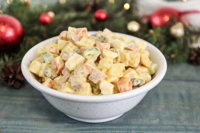 Traditional russian salad Olivier served on wooden table, closeup