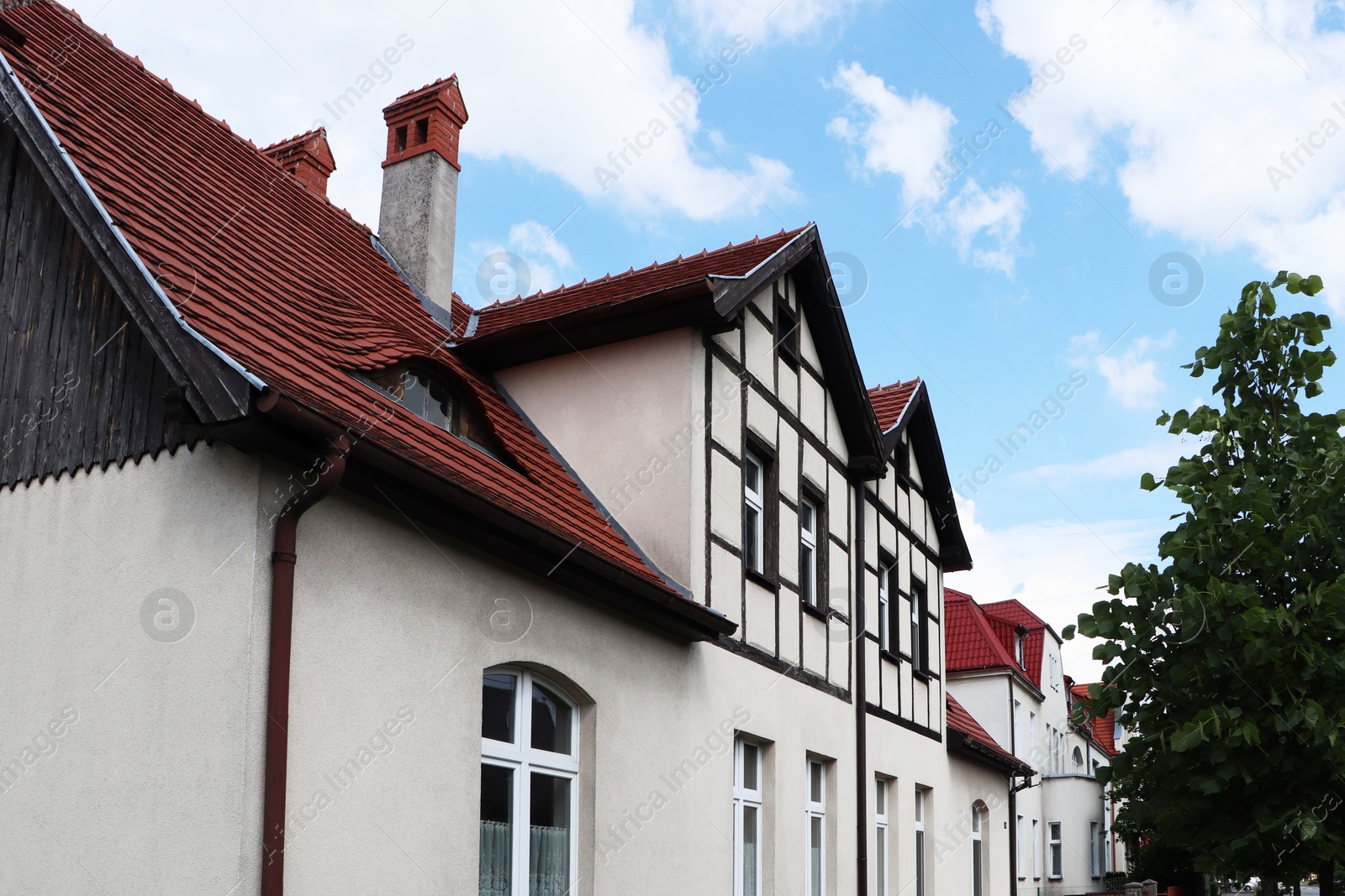 Photo of Beautiful house with brown roof against cloudy sky