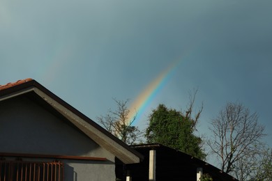 Photo of View of beautiful rainbow above house in sky