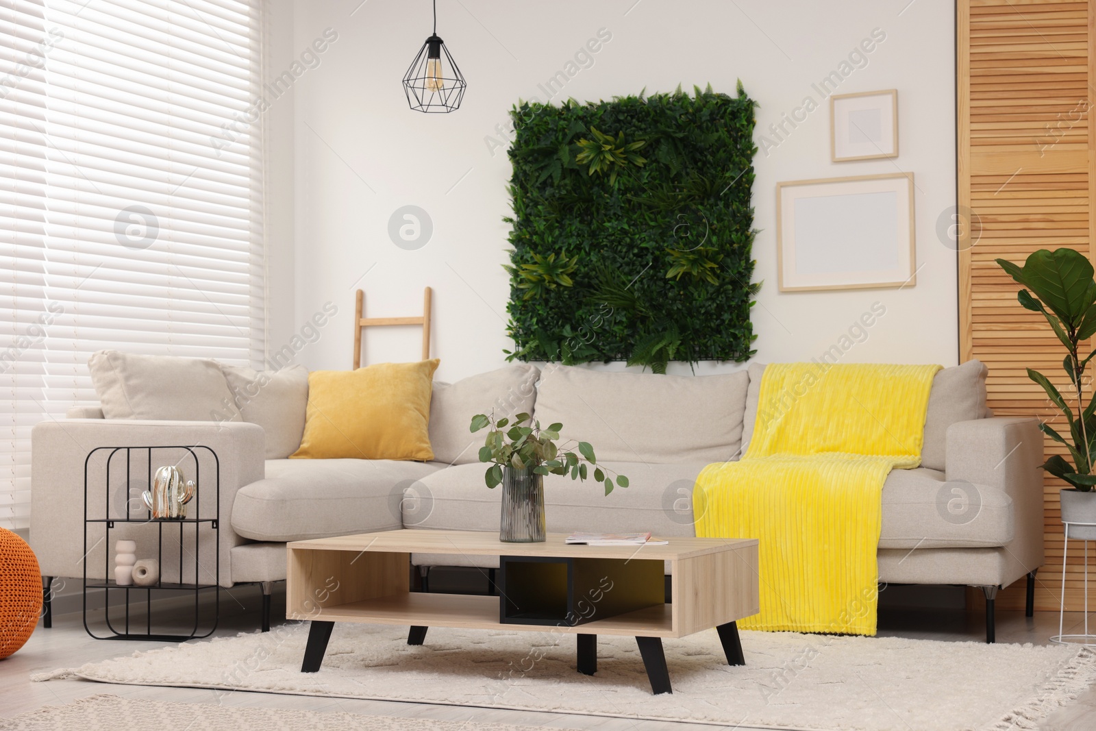 Photo of Green artificial plant wall panel and comfortable furniture in cozy living room. Interior design