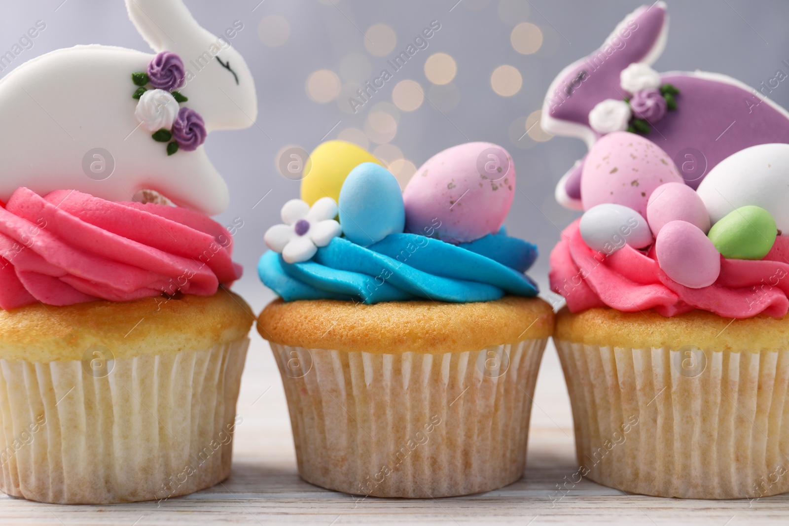 Photo of Tasty decorated Easter cupcakes on wooden table, closeup