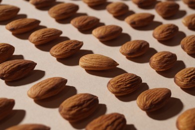 Photo of Delicious raw almonds on beige background, closeup