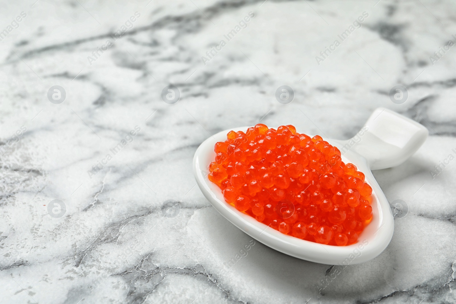 Photo of Dish with delicious red caviar on light background