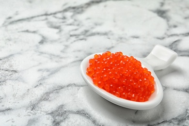 Photo of Dish with delicious red caviar on light background