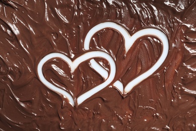 Photo of Hearts drawn in milk chocolate on white background, top view