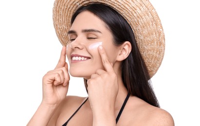 Beautiful young woman with sun protection cream on her face against white background