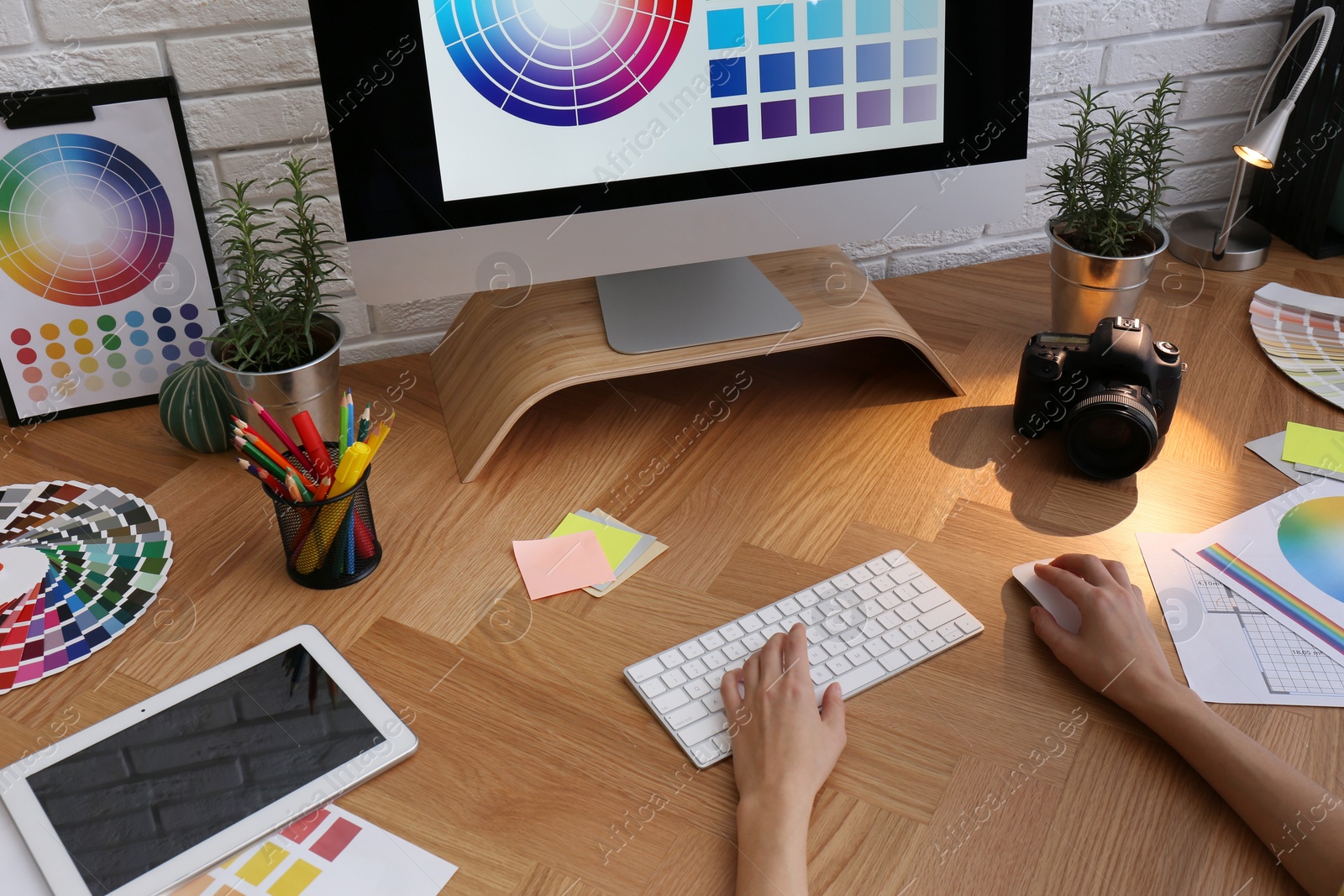 Photo of Designer working with computer at wooden table, closeup