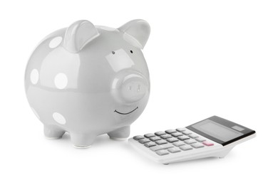 Photo of Calculator and grey piggy bank isolated on white