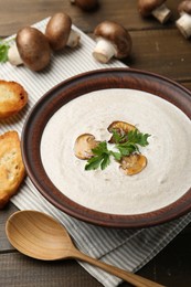 Photo of Fresh homemade mushroom soup served on wooden table