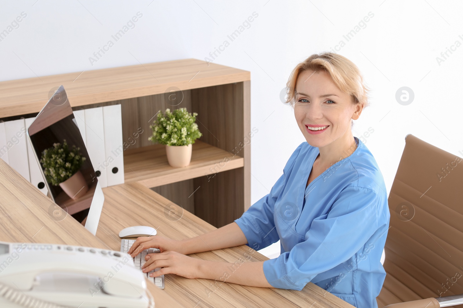 Photo of Female medical assistant at workplace in clinic. Health care service