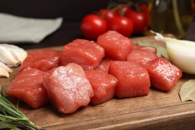 Photo of Cooking delicious goulash. Raw beef meat on wooden board, closeup