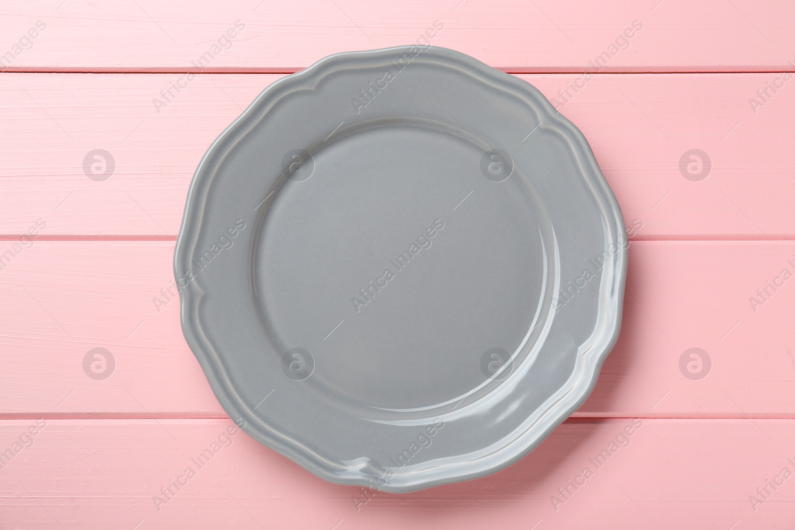 Photo of Empty grey ceramic plate on pink wooden table, top view