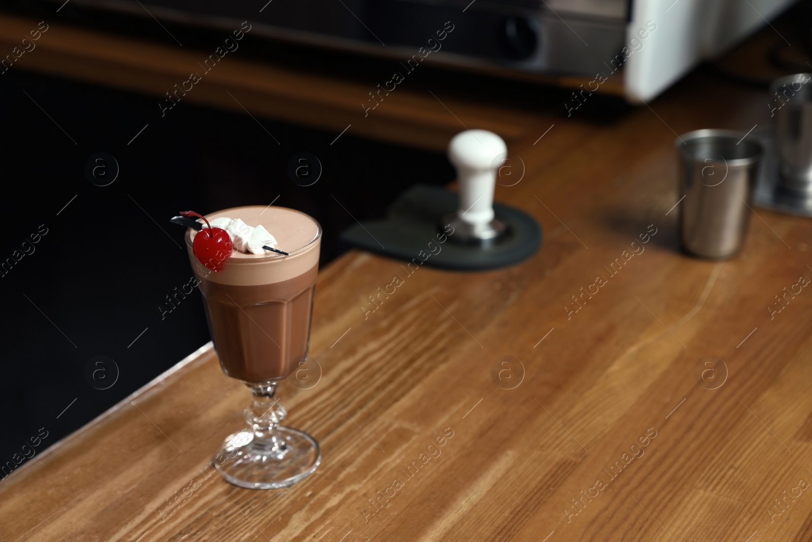 Photo of Glass of coffee drink with cherry and marshmallow on bar counter. Space for text