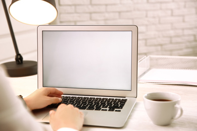 Woman working with modern laptop at white table, closeup. space for design