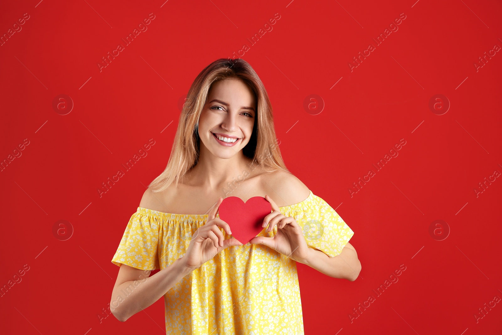 Photo of Portrait of woman with paper heart on color background