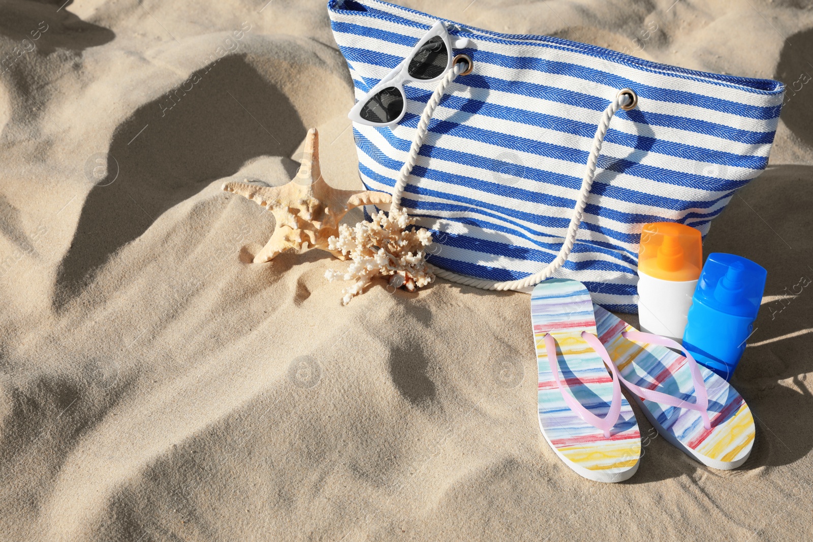 Photo of Set with stylish beach accessories on sand