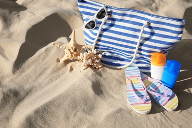 Photo of Set with stylish beach accessories on sand