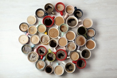 Many cups with tasty aromatic coffee on wooden table, flat lay