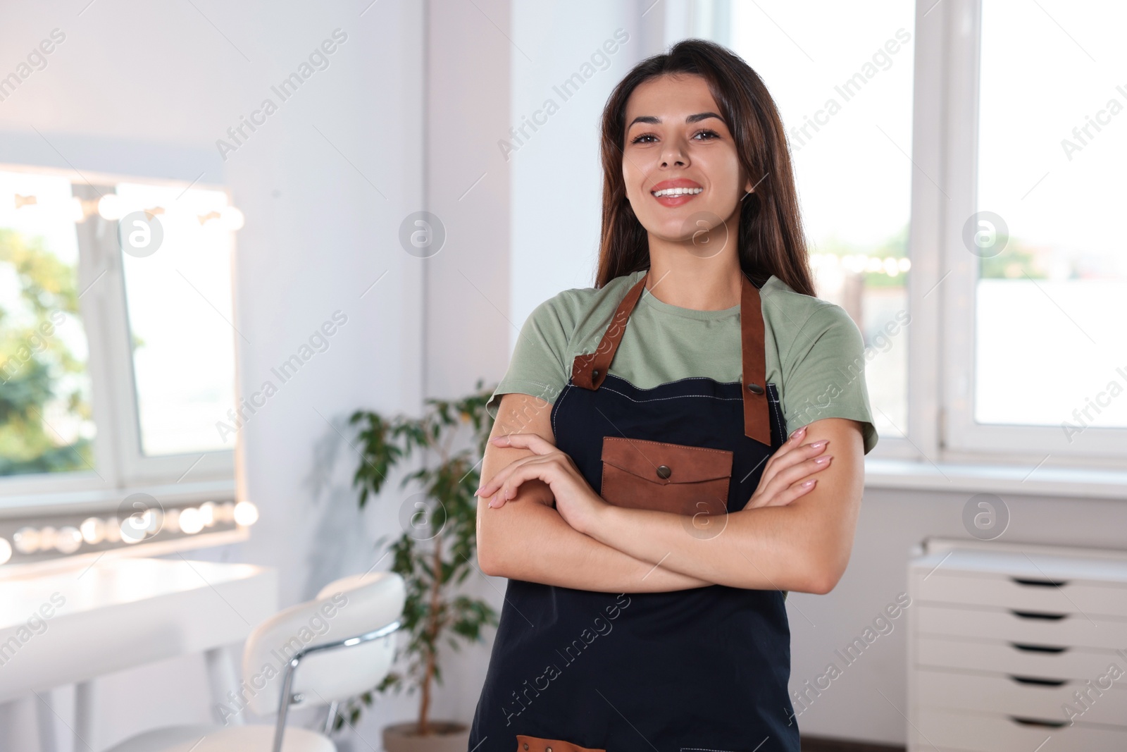 Photo of Portrait of professional hairdresser in beauty salon. Space for text