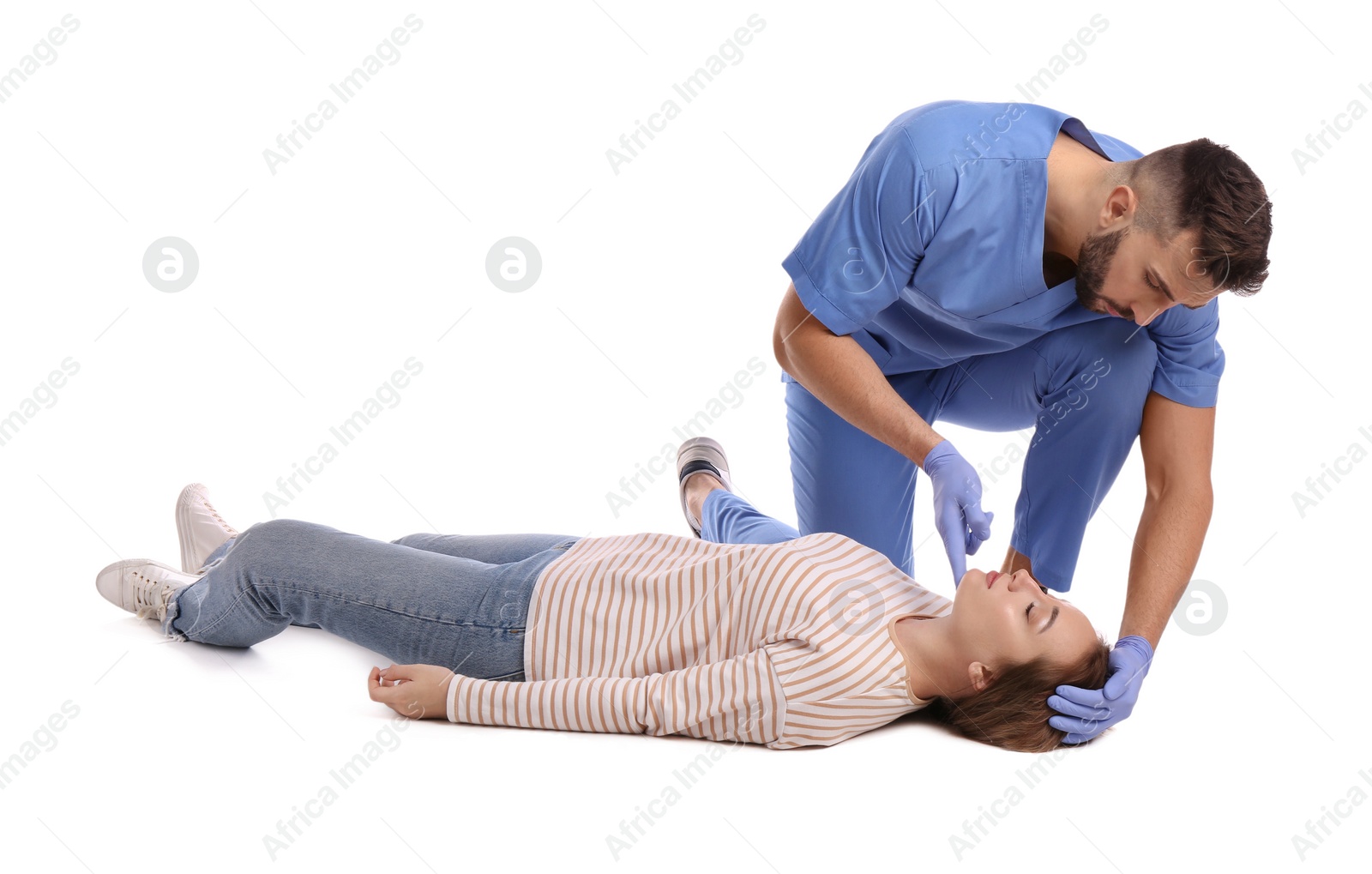 Photo of Doctor in uniform performing first aid on unconscious woman against white background