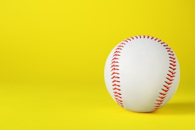 Baseball ball on yellow background, closeup with space for text. Sports game