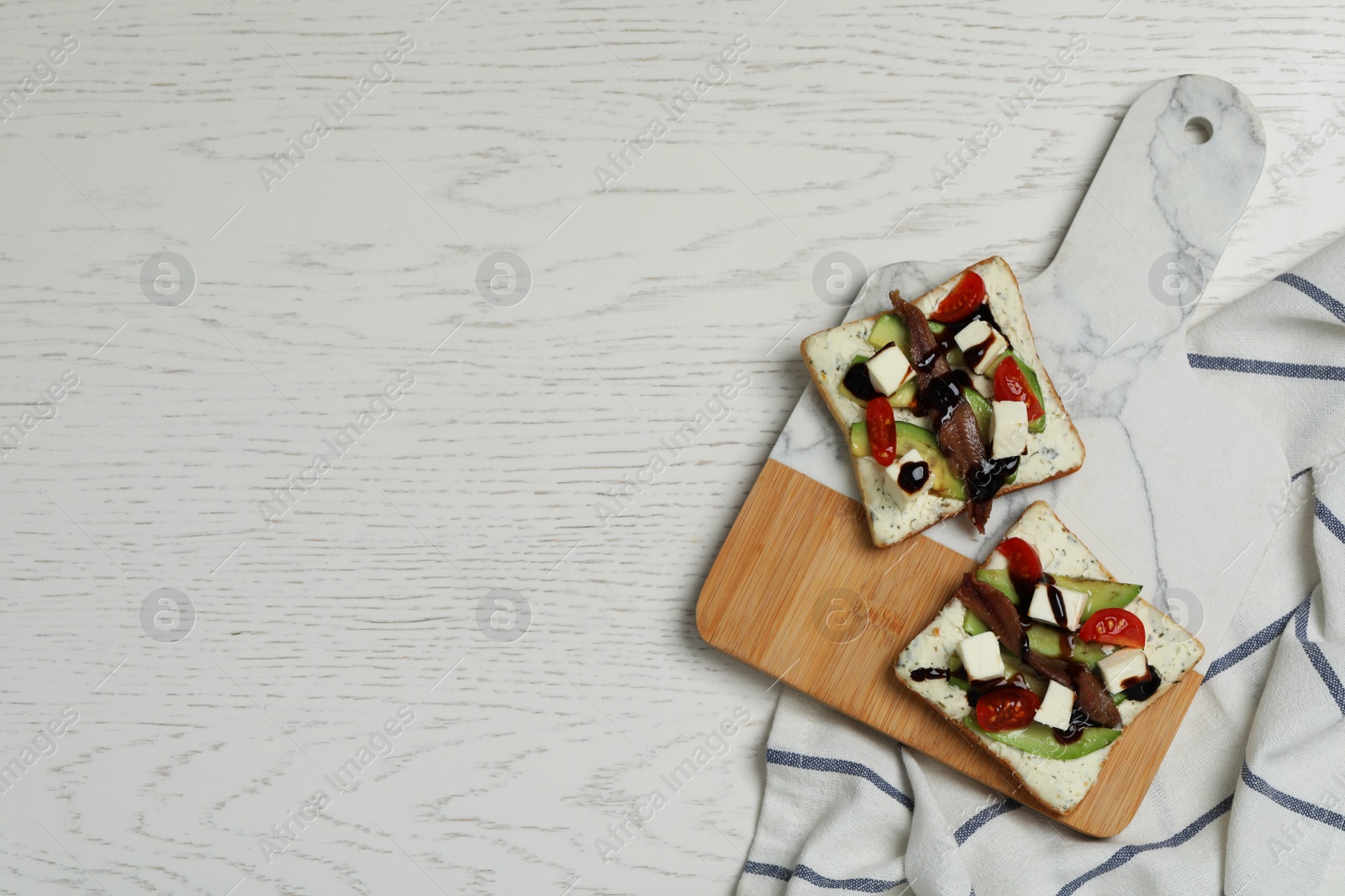 Photo of Delicious sandwiches with anchovy, cheese and tomato on white wooden table, top view. Space for text