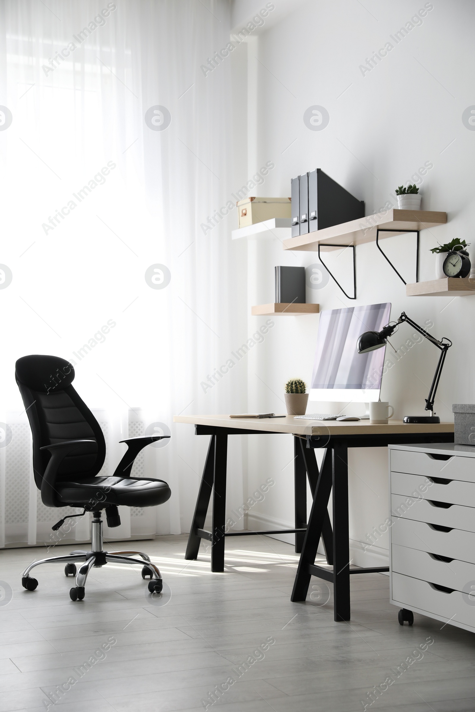 Photo of Comfortable office chair near table with modern computer