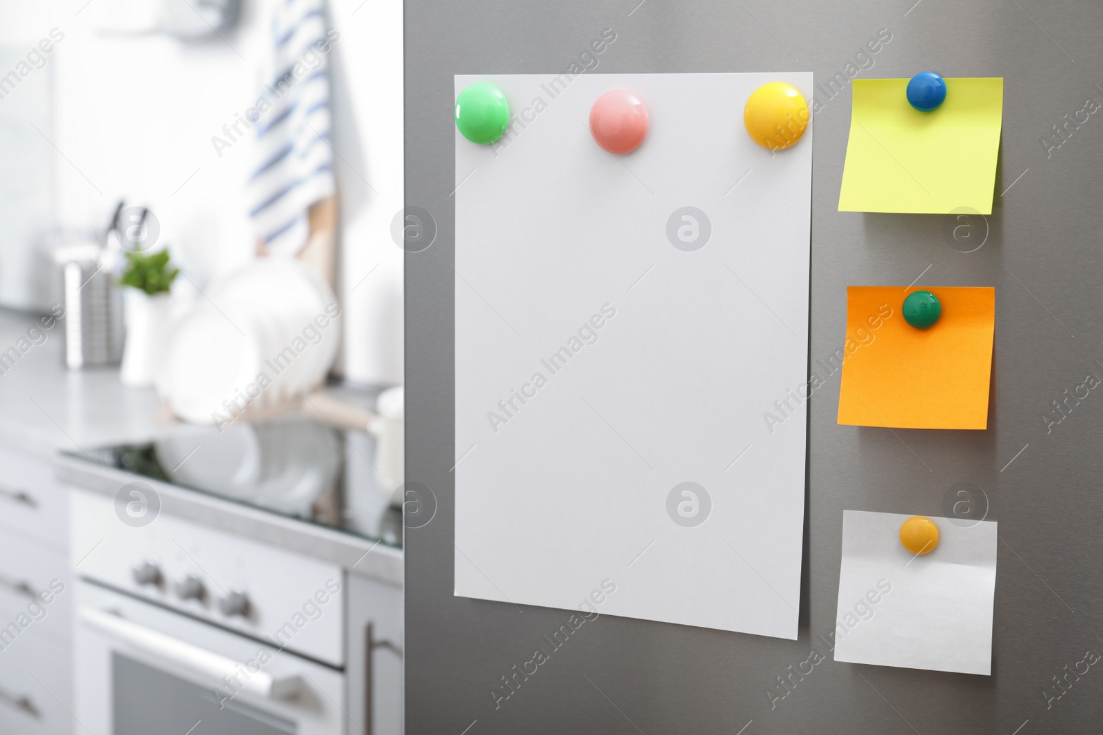 Photo of Sheets of paper with magnets on refrigerator door in kitchen. Space for text