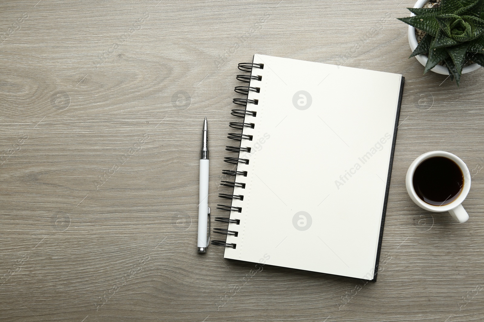 Photo of Flat lay composition with open notebook on light wooden table. Space for text