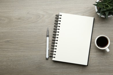 Flat lay composition with open notebook on light wooden table. Space for text