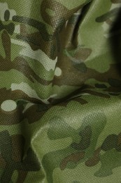 Photo of Texture of crumpled camouflage fabric as background, closeup