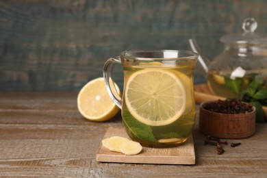 Glass cup of immunity boosting drink on wooden table, space for text