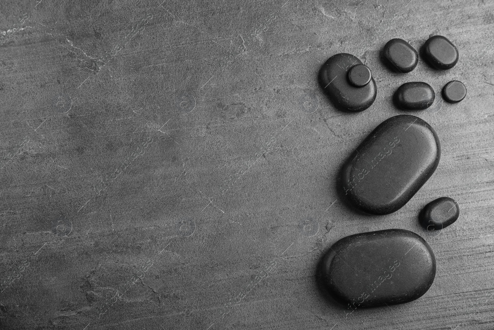 Photo of Zen stones on grey background, top view with space for text