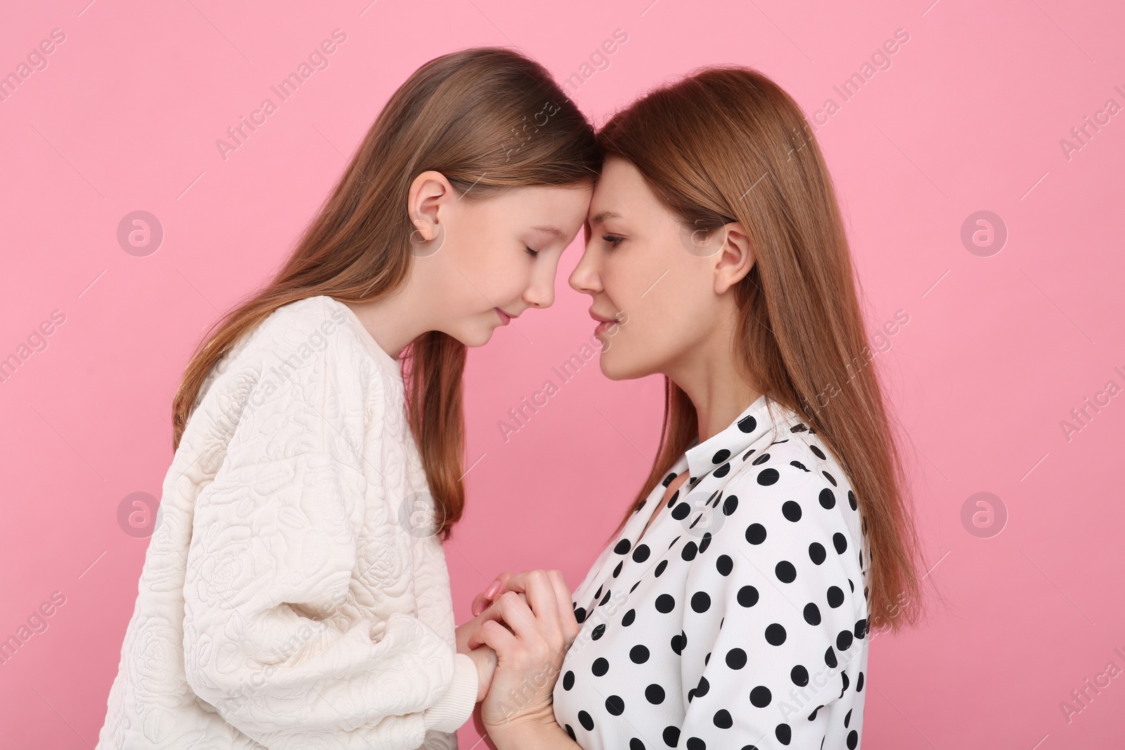 Photo of Portrait of mother and her cute daughter on pink background