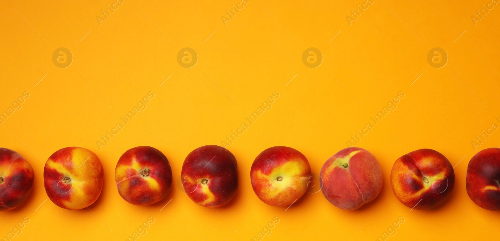 Photo of Flat lay composition with ripe peaches on orange background, space for text