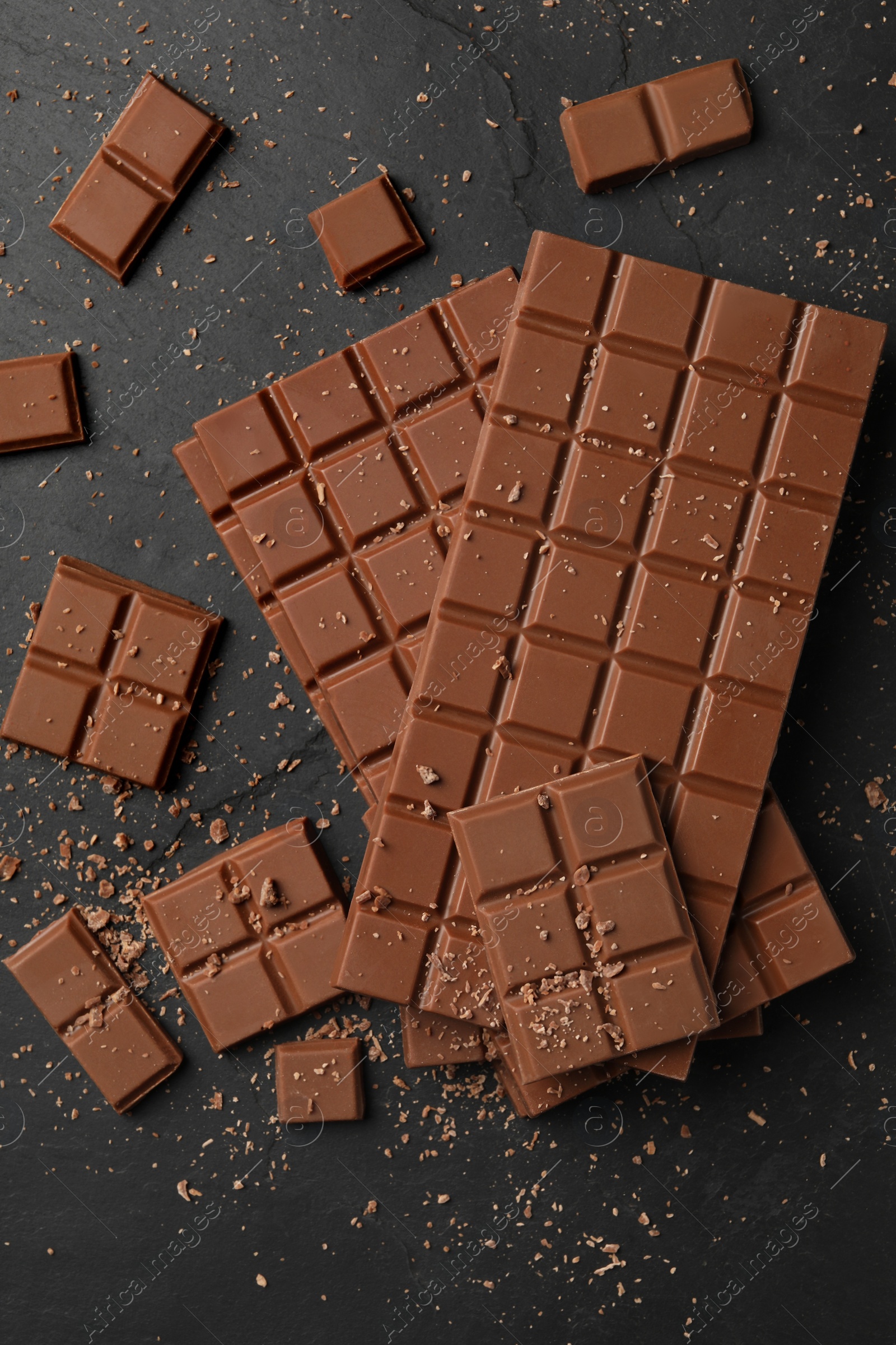 Photo of Pieces of tasty chocolate bars on grey table, flat lay