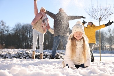 Photo of Happy family playing with snow in sunny winter park