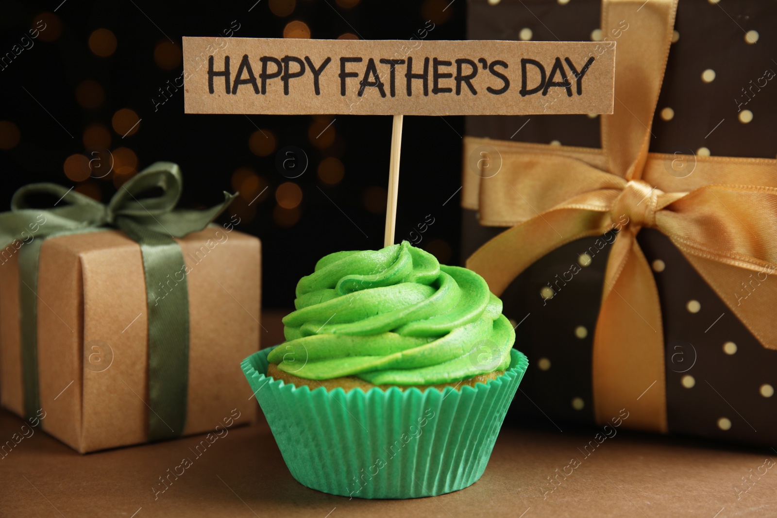 Photo of Composition with cupcake and gift boxes on brown table. Happy Father's day