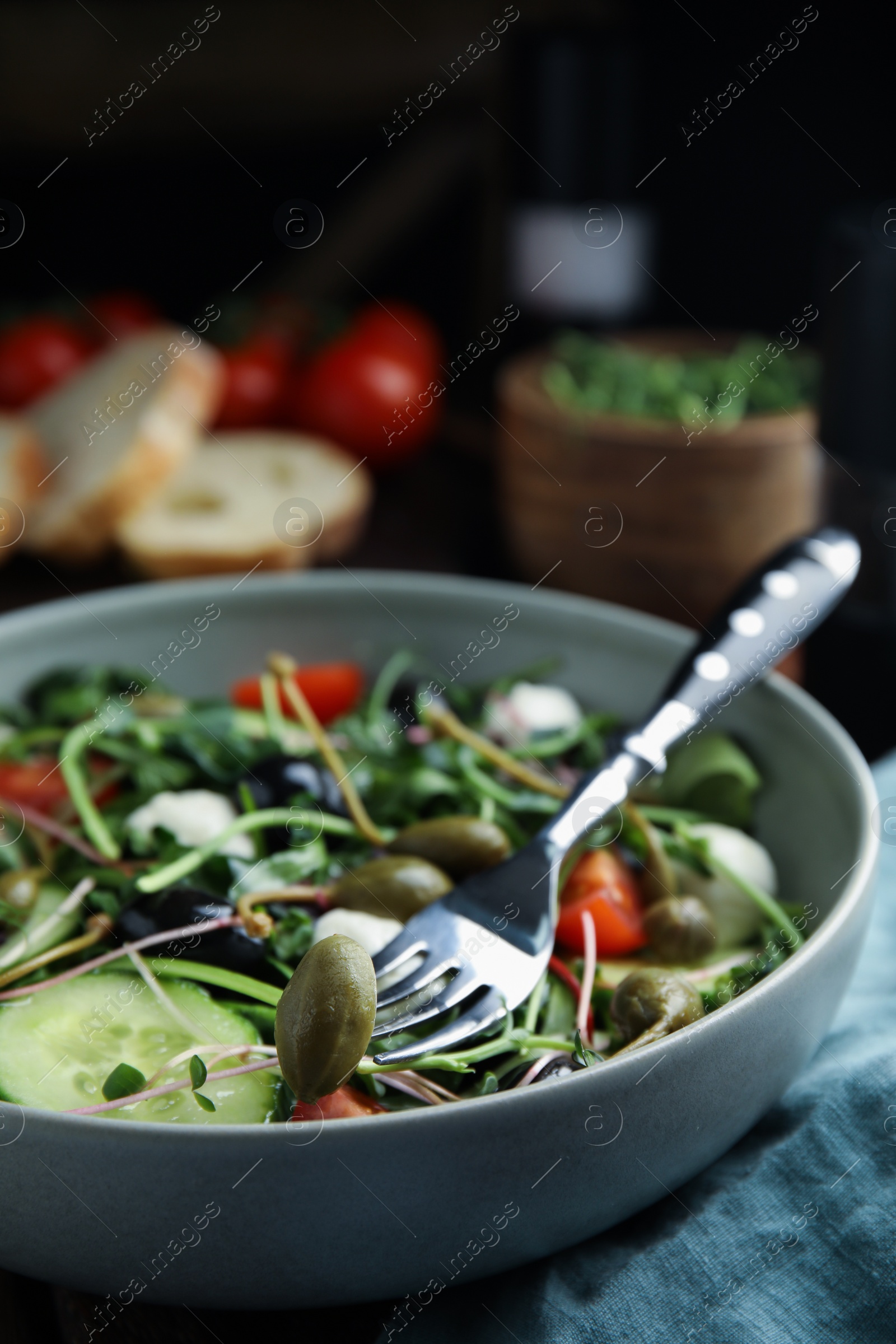 Photo of Fresh salad with vegetables, capers and mozzarella in bowl, closeup