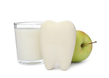 Photo of Tooth model, apple and milk on white background