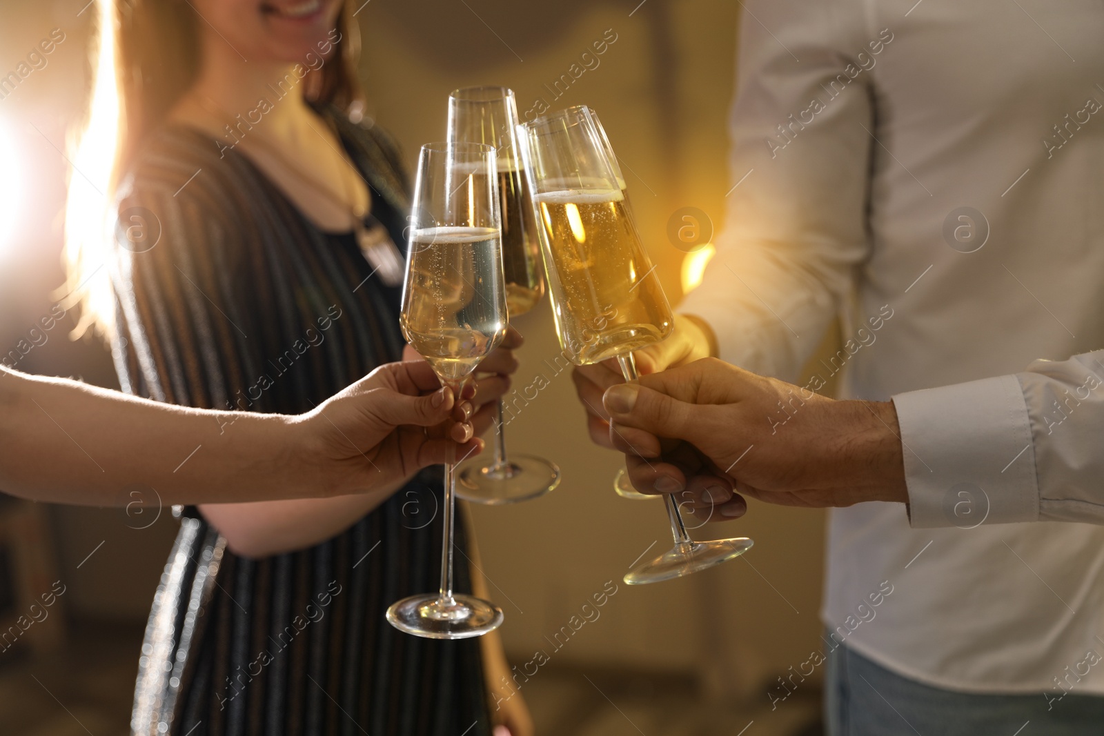 Photo of Friends clinking glasses of champagne at party, closeup