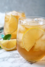 Photo of Delicious iced tea on white marble table, closeup