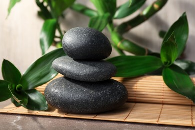 Photo of Stacked spa stones and bamboo on mat
